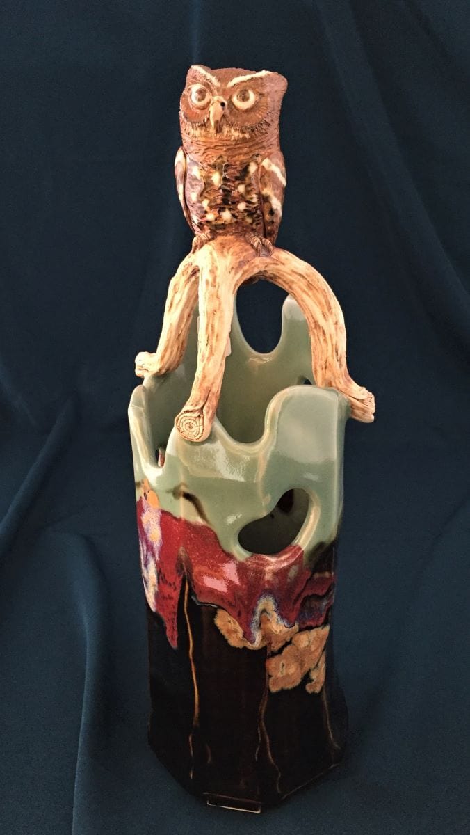 ceramic vase with branch and screech owl atop. Brown/black tenmoku and pale green celedon with red and gold glazes.