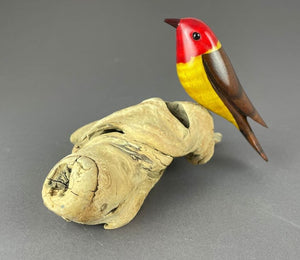 Western Tanager bird sculpture, red head, yellow breast, brown back perched on driftwood base