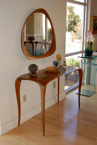 carved console table and free-form mirror